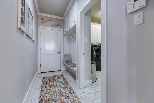 doorway with baseboards, washer / dryer, and crown molding