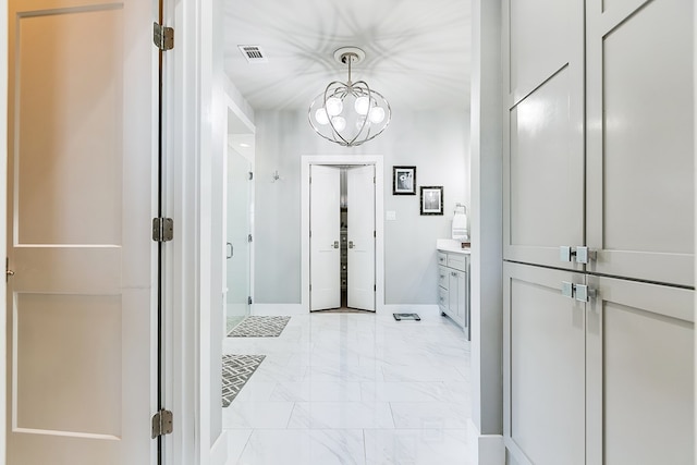 bathroom with visible vents, a stall shower, a notable chandelier, marble finish floor, and vanity