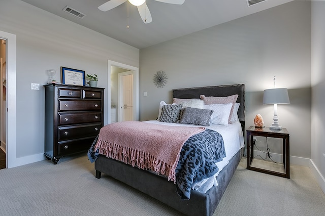 bedroom featuring visible vents, light colored carpet, baseboards, and ceiling fan