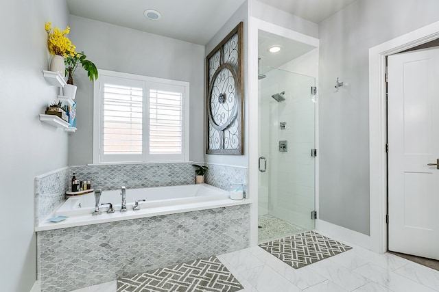 bathroom featuring a bath and a shower stall