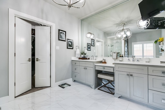 full bathroom with a notable chandelier, marble finish floor, a stall shower, and vanity