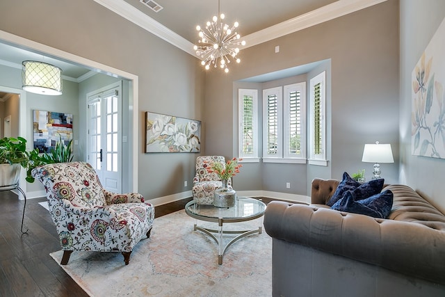 living room with an inviting chandelier, a healthy amount of sunlight, wood-type flooring, and ornamental molding