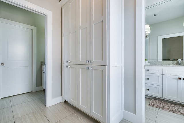 bathroom featuring tile patterned floors, visible vents, baseboards, and vanity