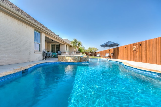 view of pool with a fenced in pool, ceiling fan, exterior kitchen, a fenced backyard, and a patio area