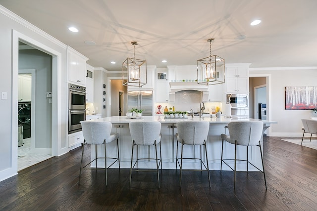 kitchen featuring white cabinetry, light countertops, crown molding, and built in appliances