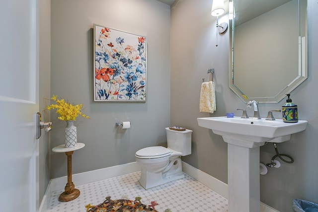 half bathroom with baseboards and toilet