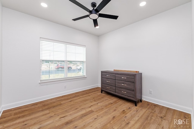 empty room with ceiling fan and light hardwood / wood-style floors