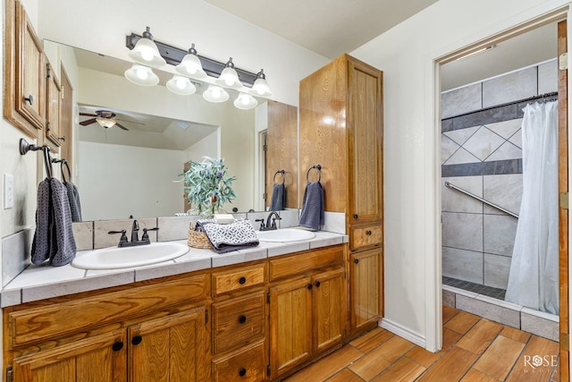 full bathroom featuring double vanity, a sink, a shower stall, and wood finished floors