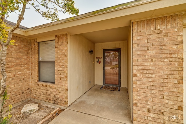 property entrance featuring brick siding