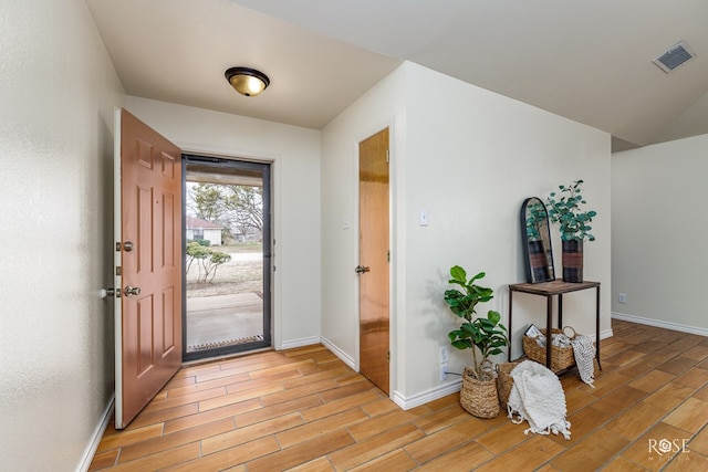 entrance foyer with light wood-type flooring, visible vents, and baseboards