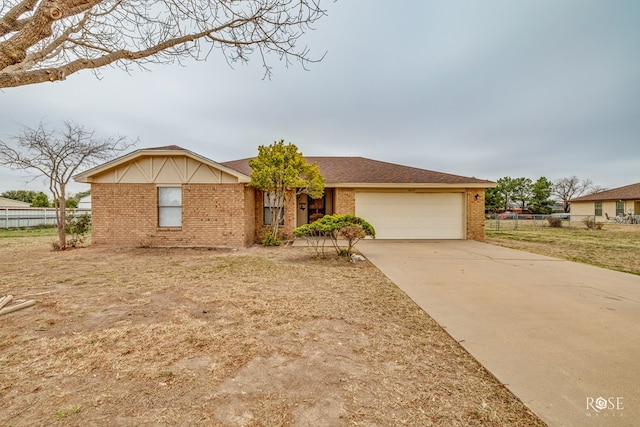 single story home with concrete driveway, brick siding, fence, and an attached garage