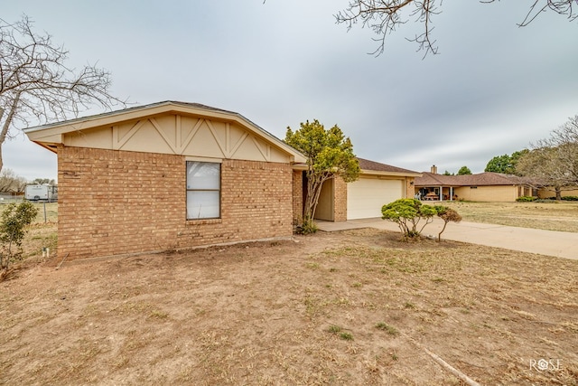 view of front of home with an attached garage, concrete driveway, and brick siding