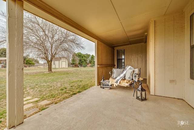 view of patio featuring a shed, fence, and an outbuilding