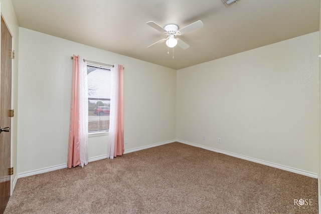 carpeted spare room with baseboards and a ceiling fan