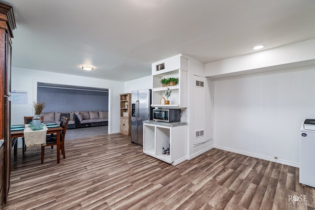 kitchen with stainless steel appliances, dark hardwood / wood-style floors, and white cabinets