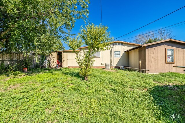 back of house with a yard and central air condition unit