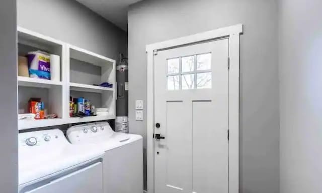 clothes washing area with laundry area, water heater, and washing machine and clothes dryer