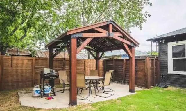 view of patio featuring a gazebo, fence, and a grill