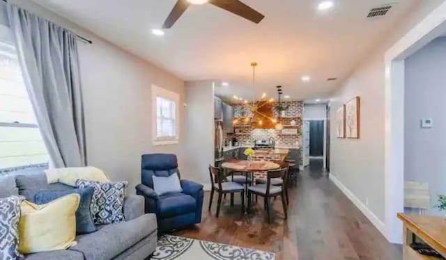 dining space featuring recessed lighting, visible vents, ceiling fan with notable chandelier, and dark wood-type flooring