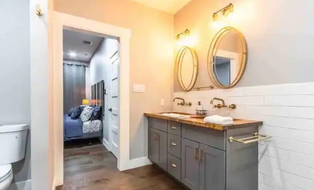 bathroom featuring visible vents, toilet, wood finished floors, and vanity