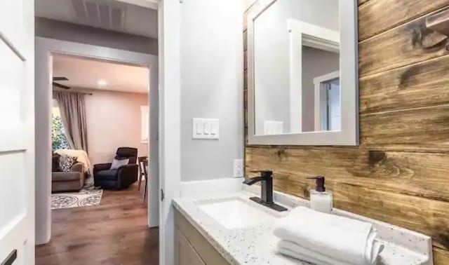 bathroom featuring vanity, wood finished floors, and wood walls