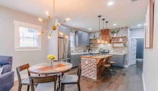 kitchen featuring backsplash, gray cabinetry, light countertops, and freestanding refrigerator