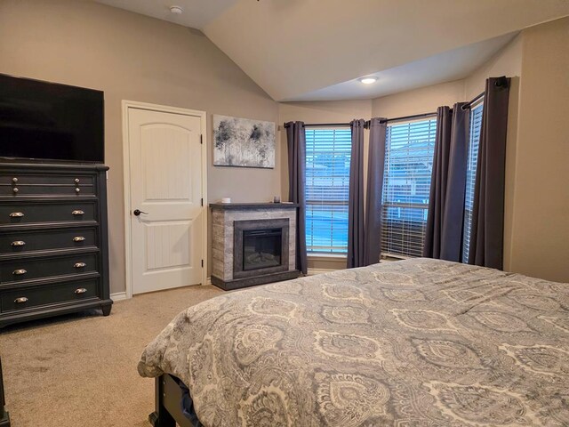 1901 Chesney Ln, San Angelo, TX 76904 - bedroom with vaulted ceiling, light carpet, a glass covered fireplace, and baseboards