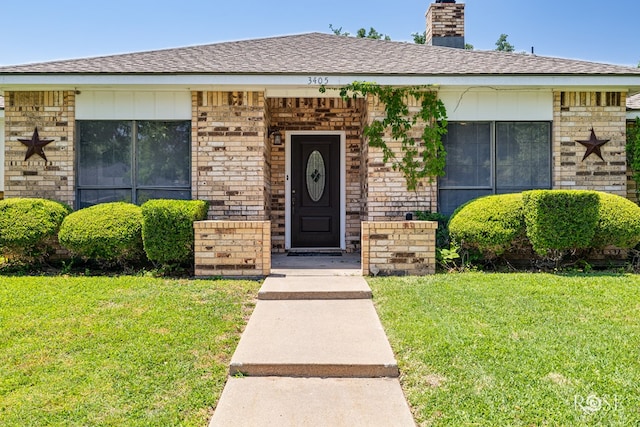 3405 Shadyhill Dr, San Angelo, TX 76904 - view of front facade featuring a front lawn, a chimney, brick siding, and a shingled roof