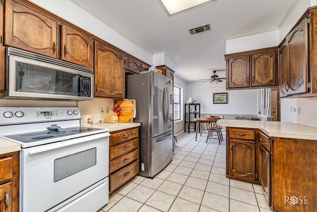 3405 Shadyhill Dr, San Angelo, TX 76904 - kitchen with stainless steel appliances, light tile patterned flooring, light countertops, a ceiling fan, and a peninsula