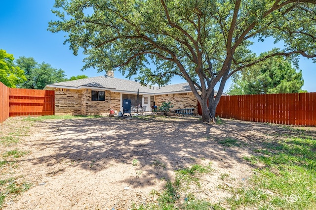 3405 Shadyhill Dr, San Angelo, TX 76904 - back of house featuring a fenced backyard, brick siding, and a chimney