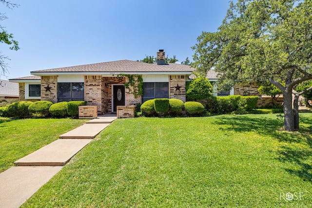 3405 Shadyhill Dr, San Angelo, TX 76904 - view of front of house featuring brick siding, a front yard, and a chimney