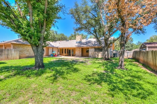 rear view of property featuring a yard and a patio area