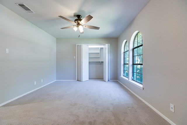 unfurnished bedroom with light carpet, a closet, and ceiling fan