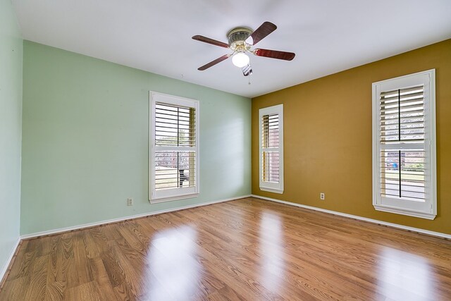 empty room with ceiling fan and light hardwood / wood-style flooring