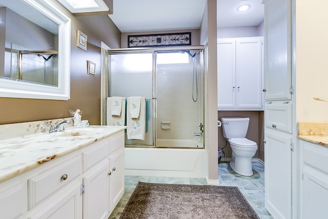 full bathroom featuring vanity, toilet, and combined bath / shower with glass door