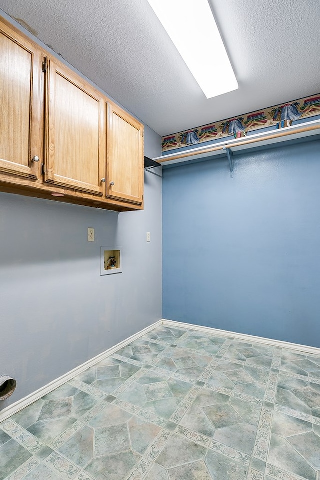 washroom with cabinets, washer hookup, and a textured ceiling