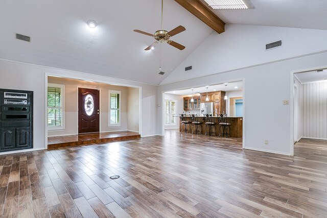 foyer entrance featuring hardwood / wood-style flooring, beamed ceiling, high vaulted ceiling, and a wealth of natural light