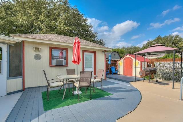 wooden deck with a grill and a storage unit