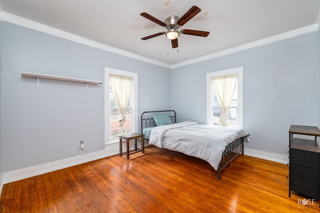 bedroom with ceiling fan, wood-type flooring, multiple windows, and ornamental molding