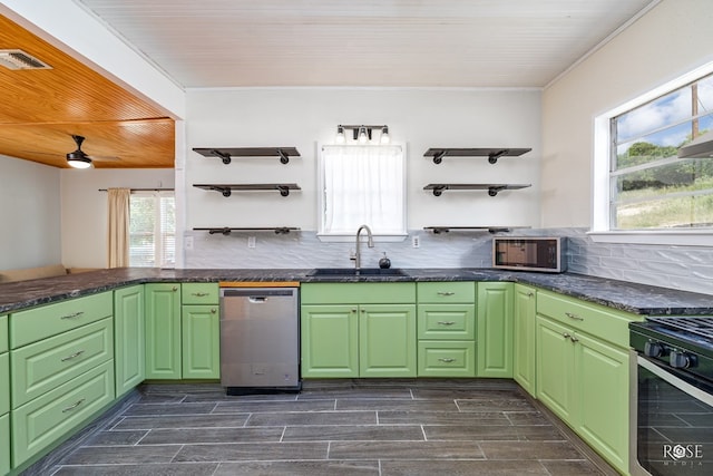 kitchen featuring appliances with stainless steel finishes, sink, green cabinets, and decorative backsplash