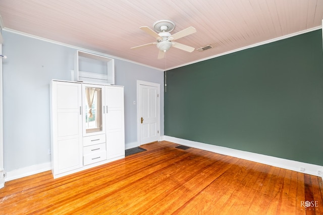 unfurnished bedroom featuring hardwood / wood-style floors, ornamental molding, and ceiling fan