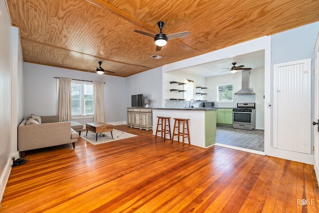 unfurnished living room featuring ceiling fan, sink, wooden ceiling, and light hardwood / wood-style floors