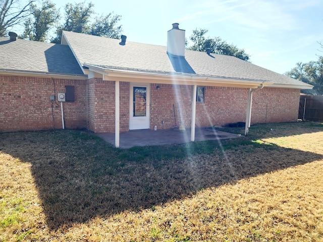 back of property with a yard and a patio area