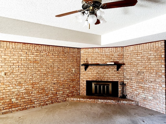 unfurnished living room featuring brick wall, a brick fireplace, carpet floors, and a textured ceiling