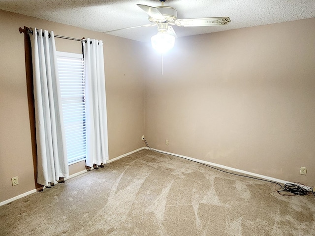 spare room featuring ceiling fan, a textured ceiling, and carpet