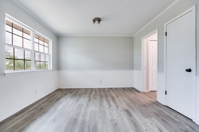 empty room featuring crown molding and light hardwood / wood-style flooring