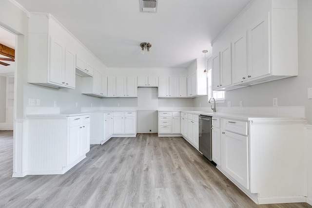 kitchen with sink, white cabinetry, decorative light fixtures, stainless steel dishwasher, and light hardwood / wood-style floors