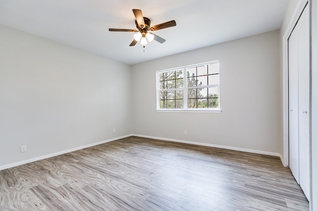 unfurnished bedroom featuring a closet, ceiling fan, and light wood-type flooring