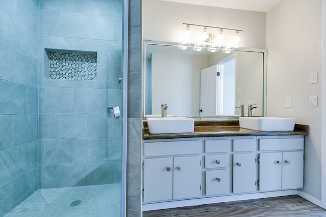 bathroom with vanity and a tile shower