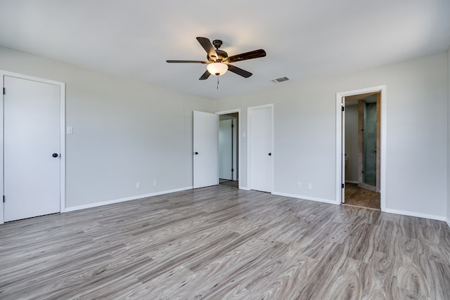 unfurnished bedroom featuring connected bathroom, ceiling fan, and light hardwood / wood-style floors